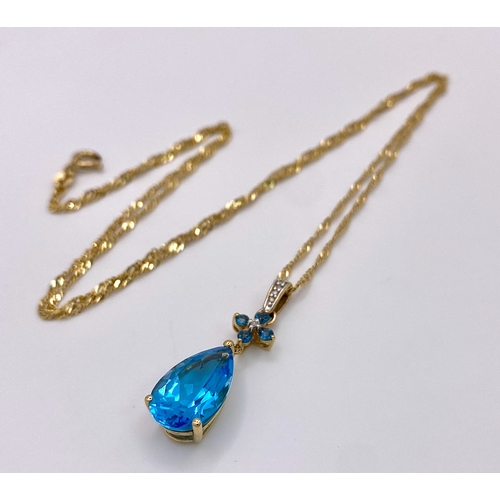 464 - A Swiss Blue Topaz 9K Gold Pendant on a 9K Singapore Chain. Pendant -3cm. Chain -58cm. 4.94g total w... 