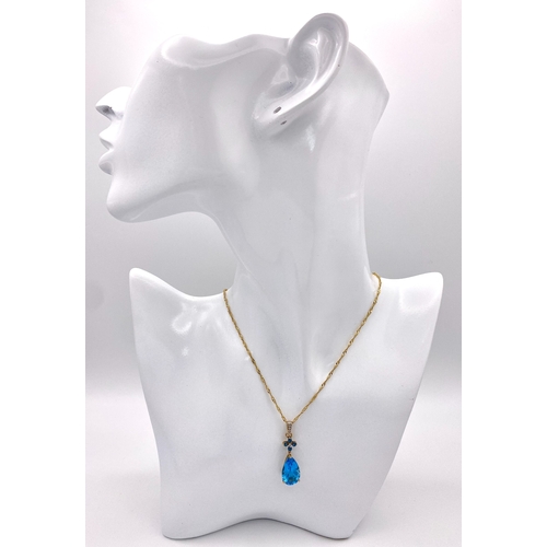 464 - A Swiss Blue Topaz 9K Gold Pendant on a 9K Singapore Chain. Pendant -3cm. Chain -58cm. 4.94g total w... 