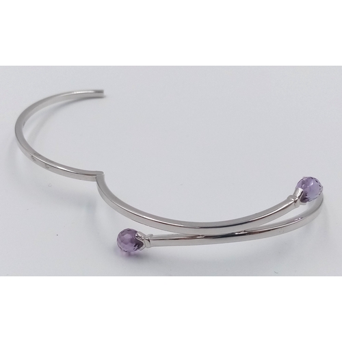 144 - A 9K WHITE GOLD AMETHYST SET BANGLE.  8.1G.