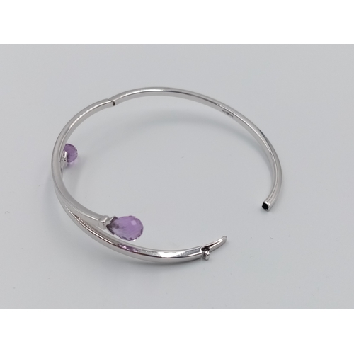 144 - A 9K WHITE GOLD AMETHYST SET BANGLE.  8.1G.