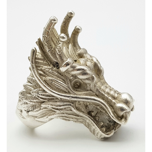 207 - A STERLING SILVER DRAGONS HEAD RING, STUNNING DETAIL AND HEAVY. Size R1/2, 4.2cm dragon head length,... 