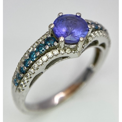 268 - A 14K White Gold Tanzanite and Diamond Ring. Central oval cut tanzanite with blue and white diamonds... 