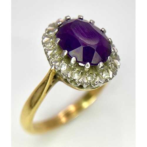 275 - An 18K Yellow Gold Amethyst and Diamond Ring. Central amethyst with a diamond halo. Size M. 4.4g tot... 