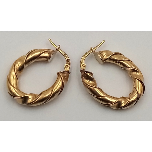 408 - A 9 K yellow gold pair of hoop earrings with a twisted design, drop: 26 mm, total weight: 5 g.