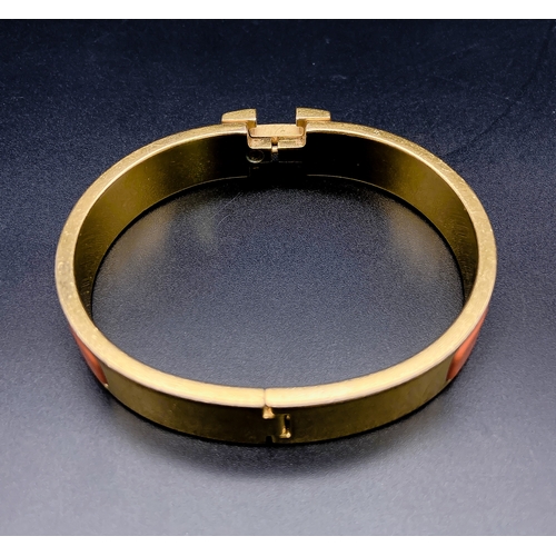 254 - A Hermes Gold Plated and Inlaid Orange Enamel Bangle. 6cm inner diameter. Comes with original Hermes... 