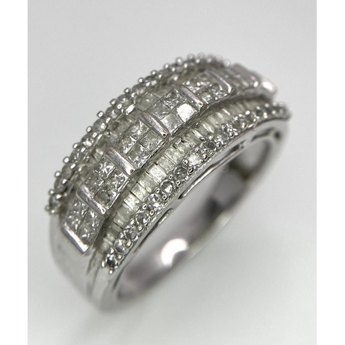 311 - A 9K White Gold Mixed Cut Diamond Ring. Five rows of, square, round and baguette cut diamonds. Size ... 