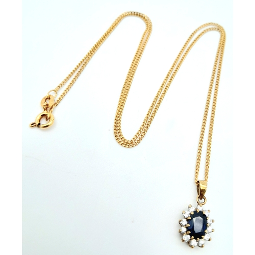 325 - A 9 K yellow gold chain necklace carrying a pendant  with an oval cut dark blue sapphire surrounded ... 