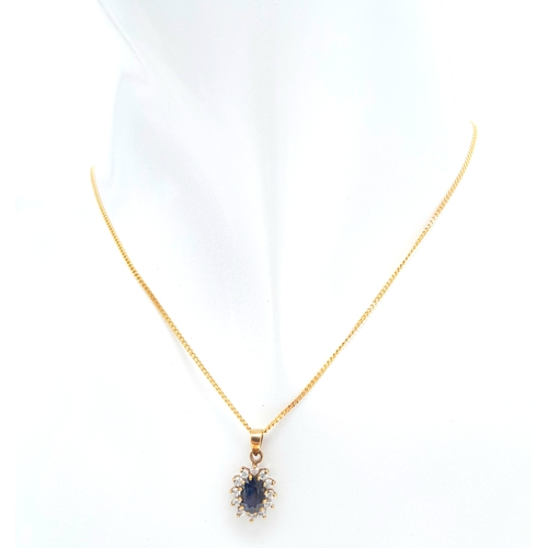 325 - A 9 K yellow gold chain necklace carrying a pendant  with an oval cut dark blue sapphire surrounded ... 