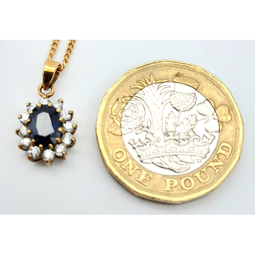 325 - A 9 K yellow gold chain necklace carrying a pendant  with an oval cut dark blue sapphire surrounded ... 