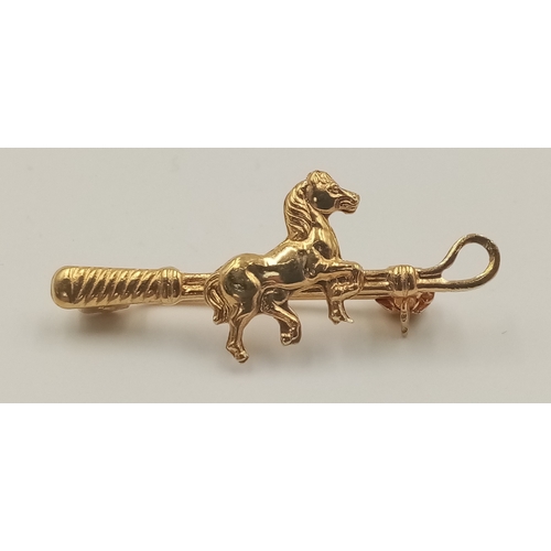 421 - An 18 K yellow gold of riding interest depicting a horse and a riding crop, pin in excellent order, ... 