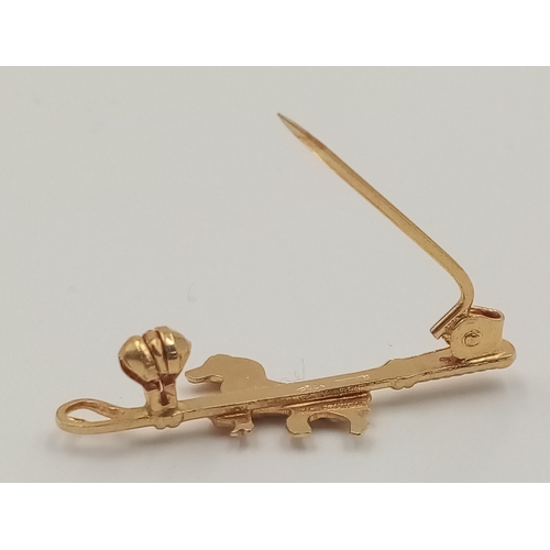 421 - An 18 K yellow gold of riding interest depicting a horse and a riding crop, pin in excellent order, ... 