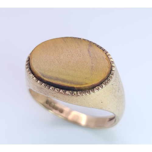 457 - A 9 K yellow gold cygnet ring with a quality tiger's eye oval flat cabochon, size: Q, weight: 4.3 g