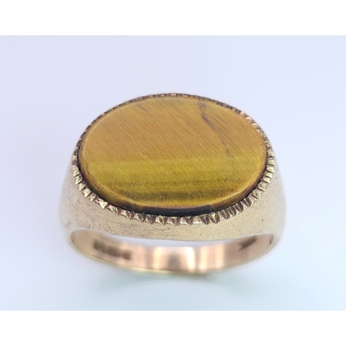 457 - A 9 K yellow gold cygnet ring with a quality tiger's eye oval flat cabochon, size: Q, weight: 4.3 g