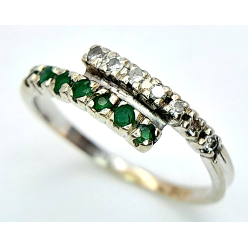 481 - A 14K WHITE GOLD DIAMOND & EMERALD 2 ROW CROSSOVER RING. Size L, 1.6g total weight. Ref: SC 8077