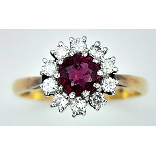 318 - An 18K Yellow Gold, Ruby and Diamond Ring. Round cut ruby with a diamond halo. Size M 1/2. 2.8g tota... 