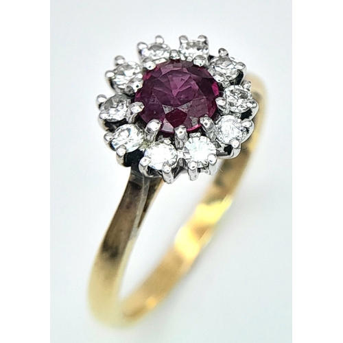 318 - An 18K Yellow Gold, Ruby and Diamond Ring. Round cut ruby with a diamond halo. Size M 1/2. 2.8g tota... 