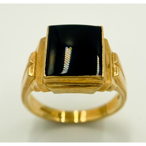 416 - A 9 K yellow gold cygnet ring with a black rectangular onyx cabochon and grooved shoulders. Size: U,... 