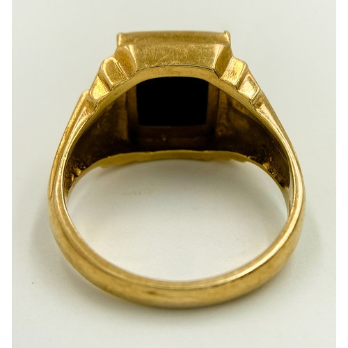 416 - A 9 K yellow gold cygnet ring with a black rectangular onyx cabochon and grooved shoulders. Size: U,... 