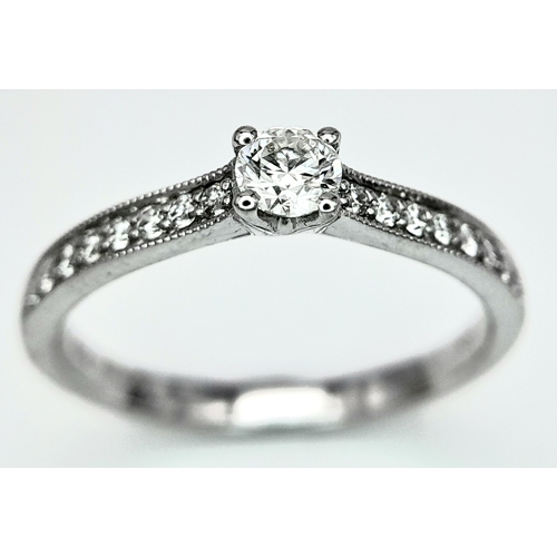 172 - AN 18K WHITE GOLD DIAMOND SOLITAIRE RING - WITH DIAMOND SET SHOULDERS. 0.35CT. TOTAL 2.6G. SIZE N