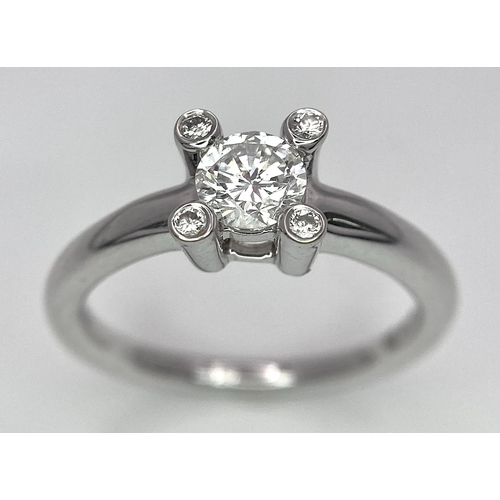 19 - AN 18K WHITE GOLD DIAMOND SOLITAIRE RING WITH FOUR DIAMOND TURRETS - 0.50CT 4.6G. SIZE M 1/2.