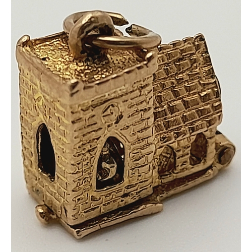 717 - A 9 K yellow gold charm in the shape of a chapel, which opens to reveal a wedding ceremony, dimensio... 