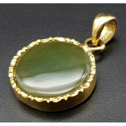 527 - A 9 K yellow gold pendant with a round green jade cabochon.  Diameter: 15 mm, weight: 2.4 g.