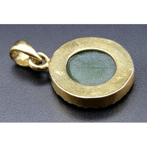 527 - A 9 K yellow gold pendant with a round green jade cabochon.  Diameter: 15 mm, weight: 2.4 g.