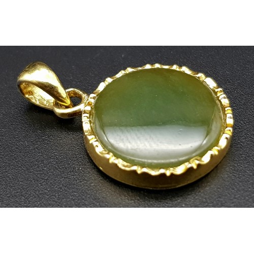 527 - A 9 K yellow gold pendant with a round green jade cabochon.  Diameter: 15 mm, weight: 2.4 g.