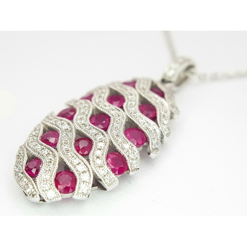 26 - AN 18K WHITE GOLD DIAMOND AND RUBY PENDANT - 0.49CT OF DIAMONDS AND 2.29CT OF RUBIES. 6.2G WEIGHT. D... 