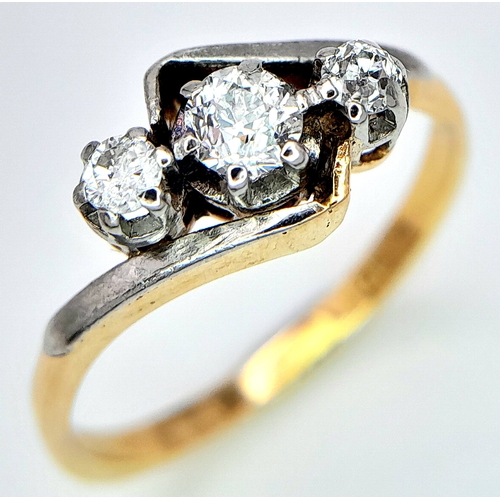 558 - AN 18K YELLOW GOLD, DIAMOND SET, CROSSOVER 3 STONE RING. 0.25CT. 2.8G. SIZE L