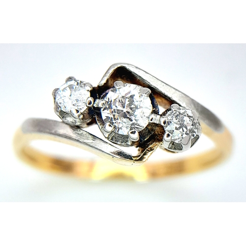 558 - AN 18K YELLOW GOLD, DIAMOND SET, CROSSOVER 3 STONE RING. 0.25CT. 2.8G. SIZE L