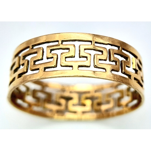 702 - A 9 K yellow gold ring with a pierced Greek key design, size: N, weight: 1.4 g.