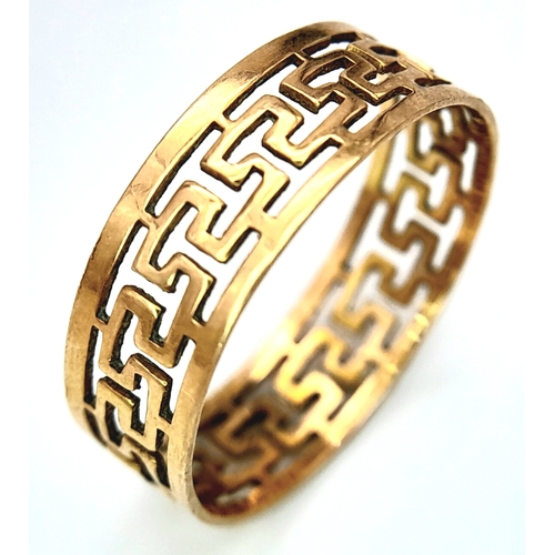 702 - A 9 K yellow gold ring with a pierced Greek key design, size: N, weight: 1.4 g.