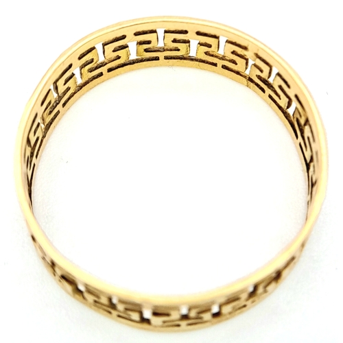 702 - A 9 K yellow gold ring with a pierced Greek key design, size: N, weight: 1.4 g.