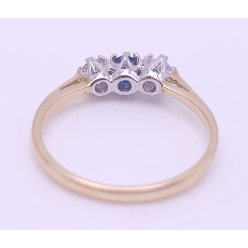 579 - AN 18K YELLOW GOLD DIAMOND AND SAPPHIRE 3 STONE RING. 0.30CT DIAMONDS. 2.4G. SIZE O.