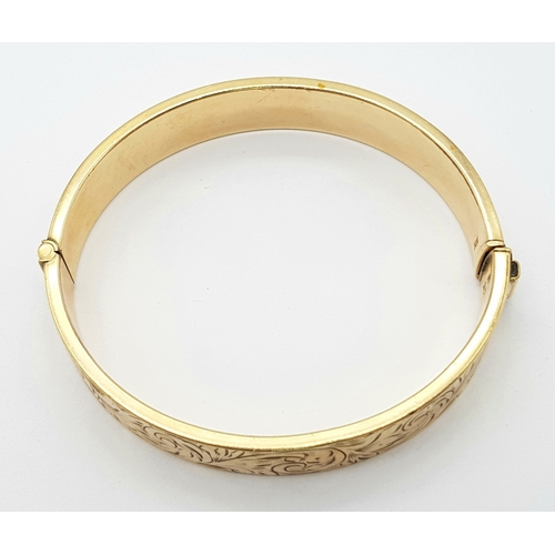 636 - A 9K GOLD VINTAGE HINGED BANGLE WITH A METAL CORE .   23.9gms