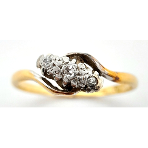 709 - A vintage, 18 K yellow gold ring with a trilogy of round cut diamonds in a twisted design. Ring size... 