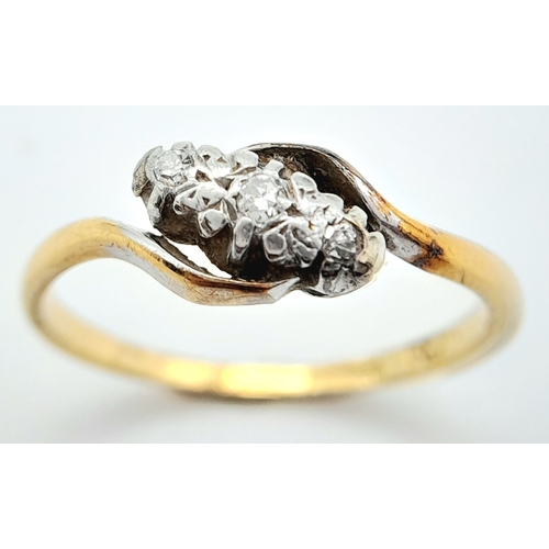 709 - A vintage, 18 K yellow gold ring with a trilogy of round cut diamonds in a twisted design. Ring size... 