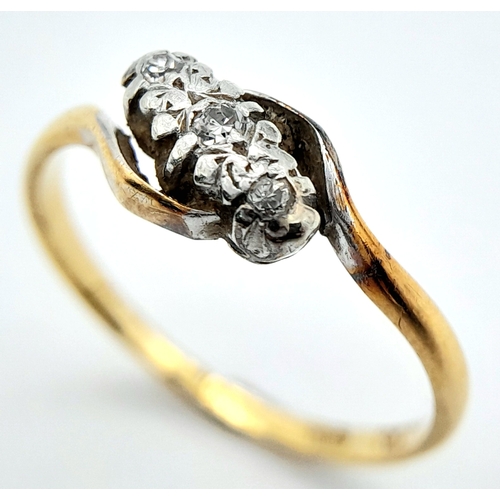 709 - A vintage, 18 K yellow gold ring with a trilogy of round cut diamonds in a twisted design. Ring size... 