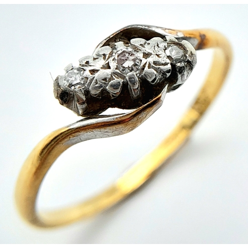 709 - A vintage, 18 K yellow gold ring with a trilogy of round cut diamonds in a twisted design. Ring size... 