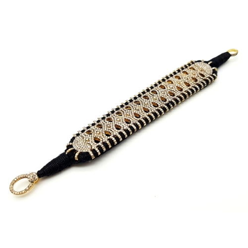 147 - A Brilliantly Unique Handcrafted Designer Diamond Bracelet. A black woven textile bracelet strap ado... 