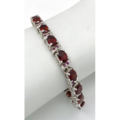 105 - A Garnet Tennis Bracelet set in 925 Sterling silver. 36ctw. W-25.60g. 18cm.