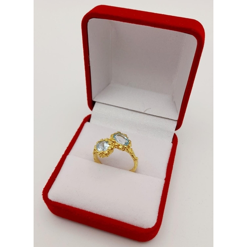 167 - A very feminine sterling silver and yellow gold ring with two oval cut aquamarines symbolising purit... 