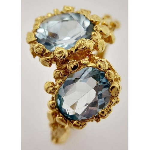 167 - A very feminine sterling silver and yellow gold ring with two oval cut aquamarines symbolising purit... 