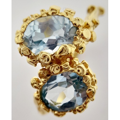 167 - A very feminine sterling silver and yellow gold ring with two oval cut aquamarines symbolising purit... 