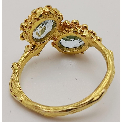 167 - A very feminine sterling silver and yellow gold ring with two oval cut aquamarines symbolising purit... 