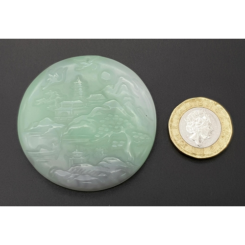 540 - A Chinese Pale Green and White Jade Circular Pendant with Village Decoration. 5cm diameter.