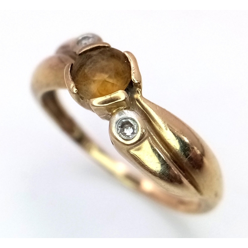 561 - A 9K Yellow Gold Citrine and Diamond Crossover Ring. Size J.
1.8g total weight.