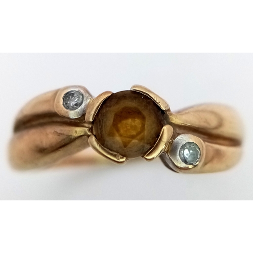 561 - A 9K Yellow Gold Citrine and Diamond Crossover Ring. Size J.
1.8g total weight.