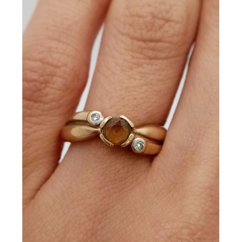 561 - A 9K Yellow Gold Citrine and Diamond Crossover Ring. Size J.
1.8g total weight.